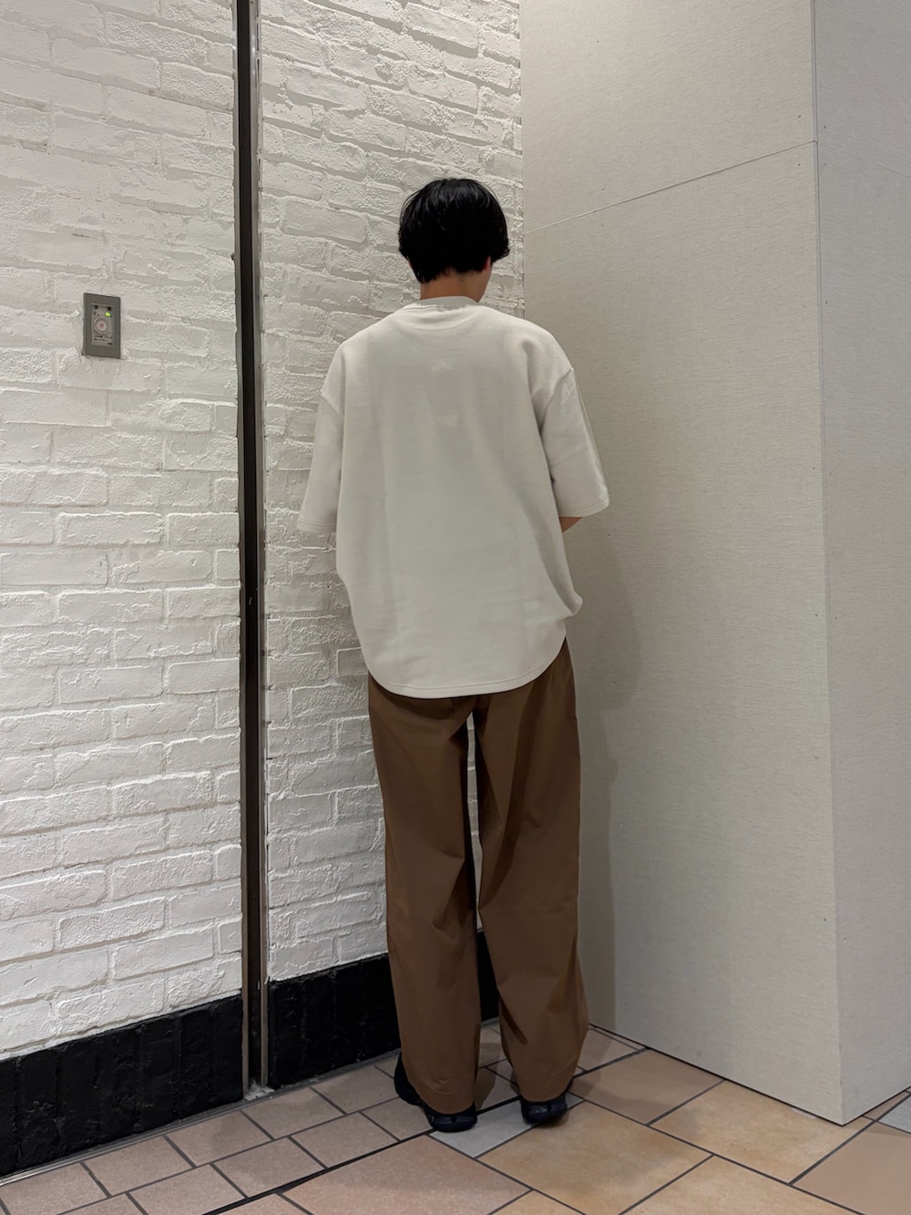 ホワイト系のTシャツ/カットソー、ブラウン系のその他パンツ、ブラック系のスニーカーを着用したメンズの春コーディネートの4枚目の写真