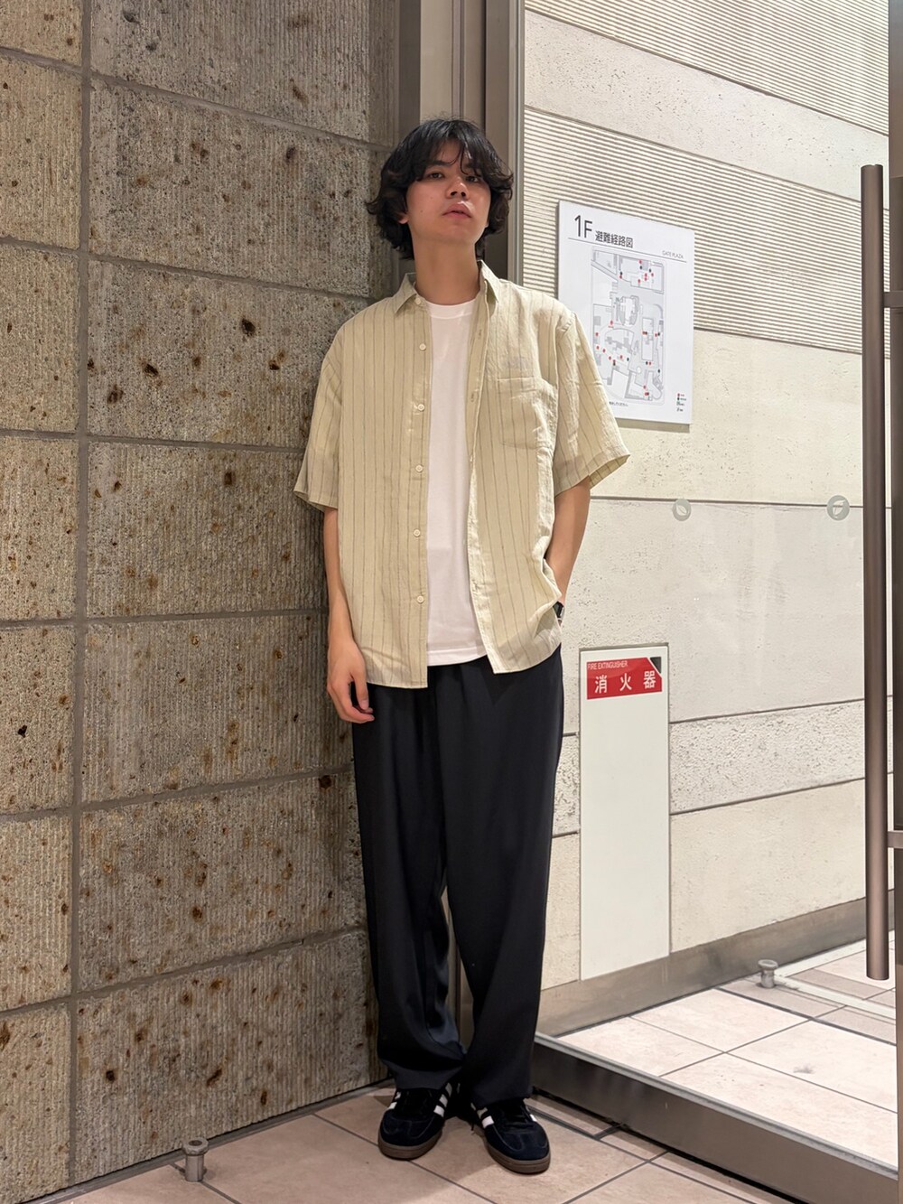 ホワイト系のTシャツ/カットソー、グレー系のその他パンツ、ブラック系のスニーカーを着用したメンズの夏コーディネートの2枚目の写真