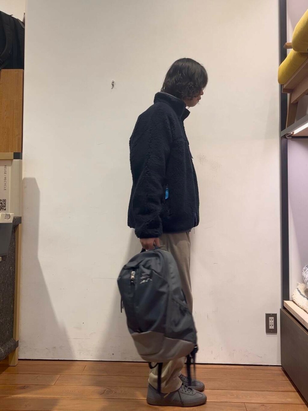 ブルー系のバックパック/リュック、ベージュ系のその他パンツ、ブラック系のテーラードジャケットを着用したメンズの冬コーディネートの2枚目の写真