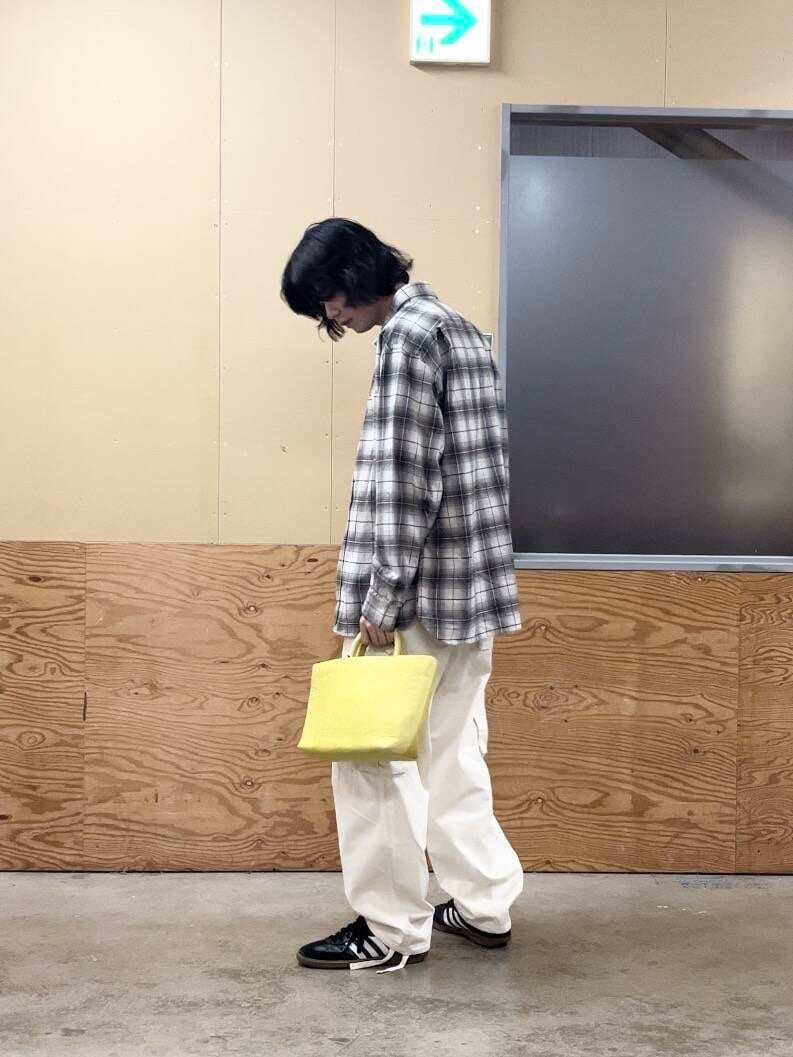 イエロー系のトートバッグ、ホワイト系のその他パンツ、ベージュ系のシャツ/ブラウスを着用したメンズの秋コーディネートの2枚目の写真