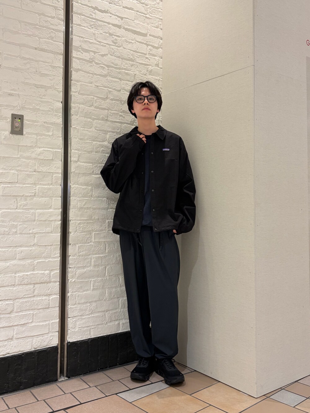 ブラック系のカバーオール、ブルー系のTシャツ/カットソー、ブラック系のスニーカーを着用したメンズの春コーディネートの7枚目の写真