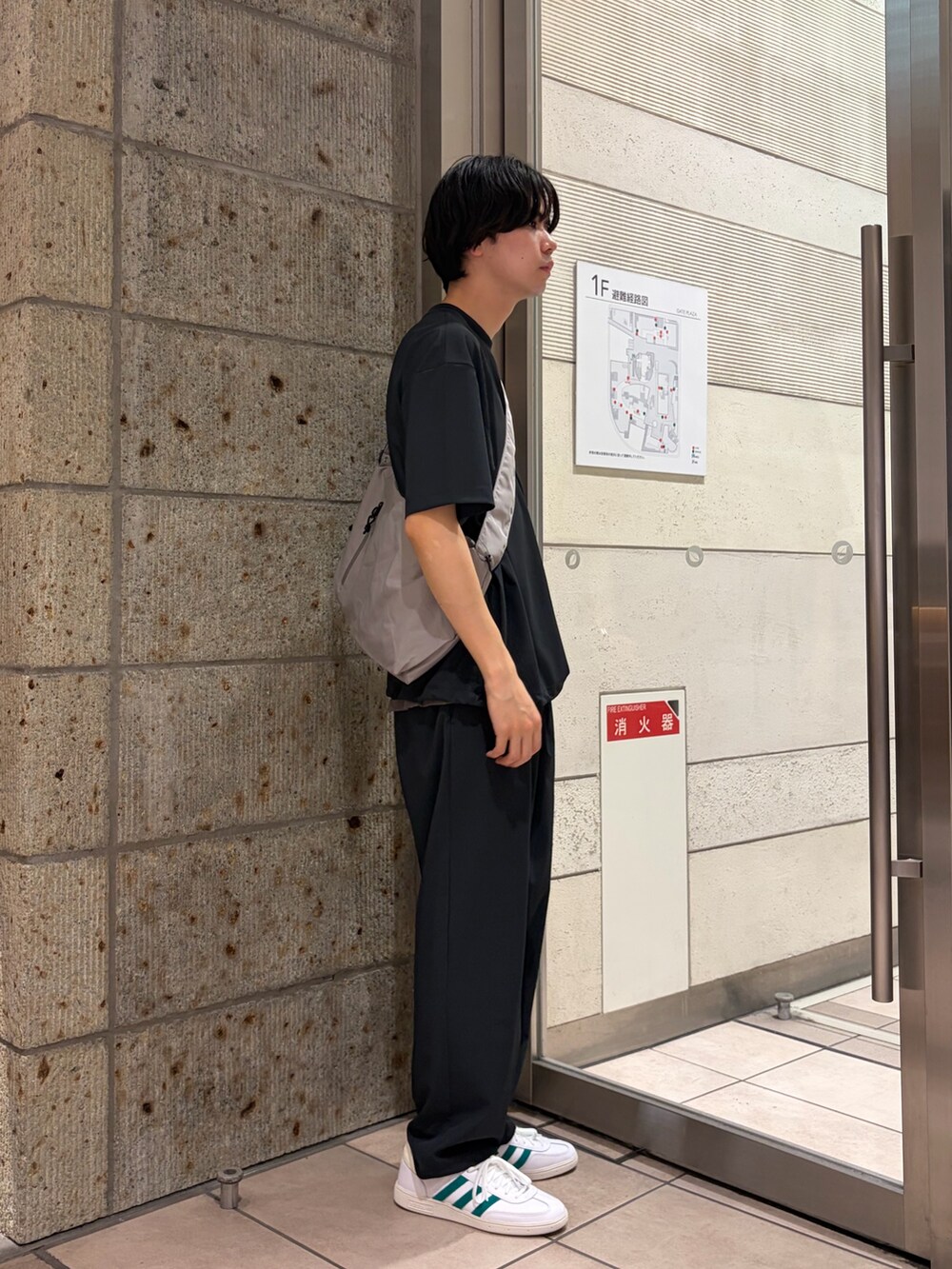 グレー系のTシャツ/カットソー、グレー系のショルダーバッグ、ブラック系のその他パンツを着用したメンズの春コーディネートの3枚目の写真