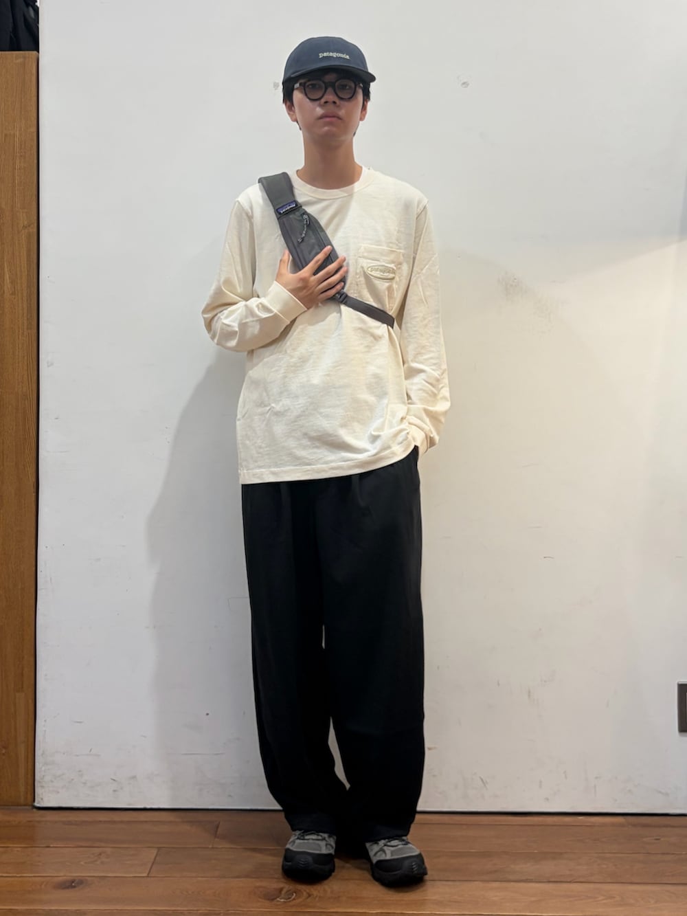 ホワイト系のTシャツ/カットソー、グレー系のショルダーバッグ、ブラック系のその他パンツを着用したメンズの秋コーディネートの5枚目の写真