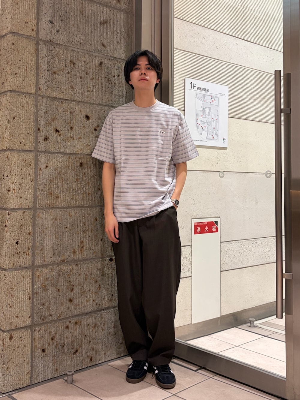 グレー系のTシャツ/カットソー、ブラウン系のその他パンツ、ブラック系のスニーカーを着用したメンズの春コーディネートの2枚目の写真