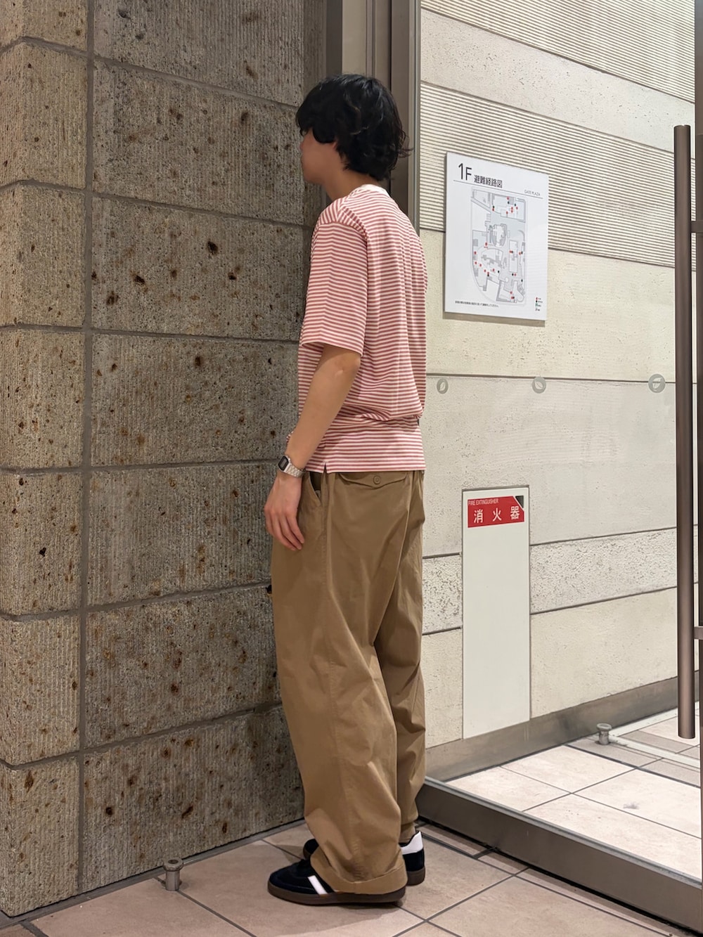 レッド系のTシャツ/カットソー、ベージュ系のその他パンツ、ブラック系のスニーカーを着用したメンズの春コーディネートの3枚目の写真