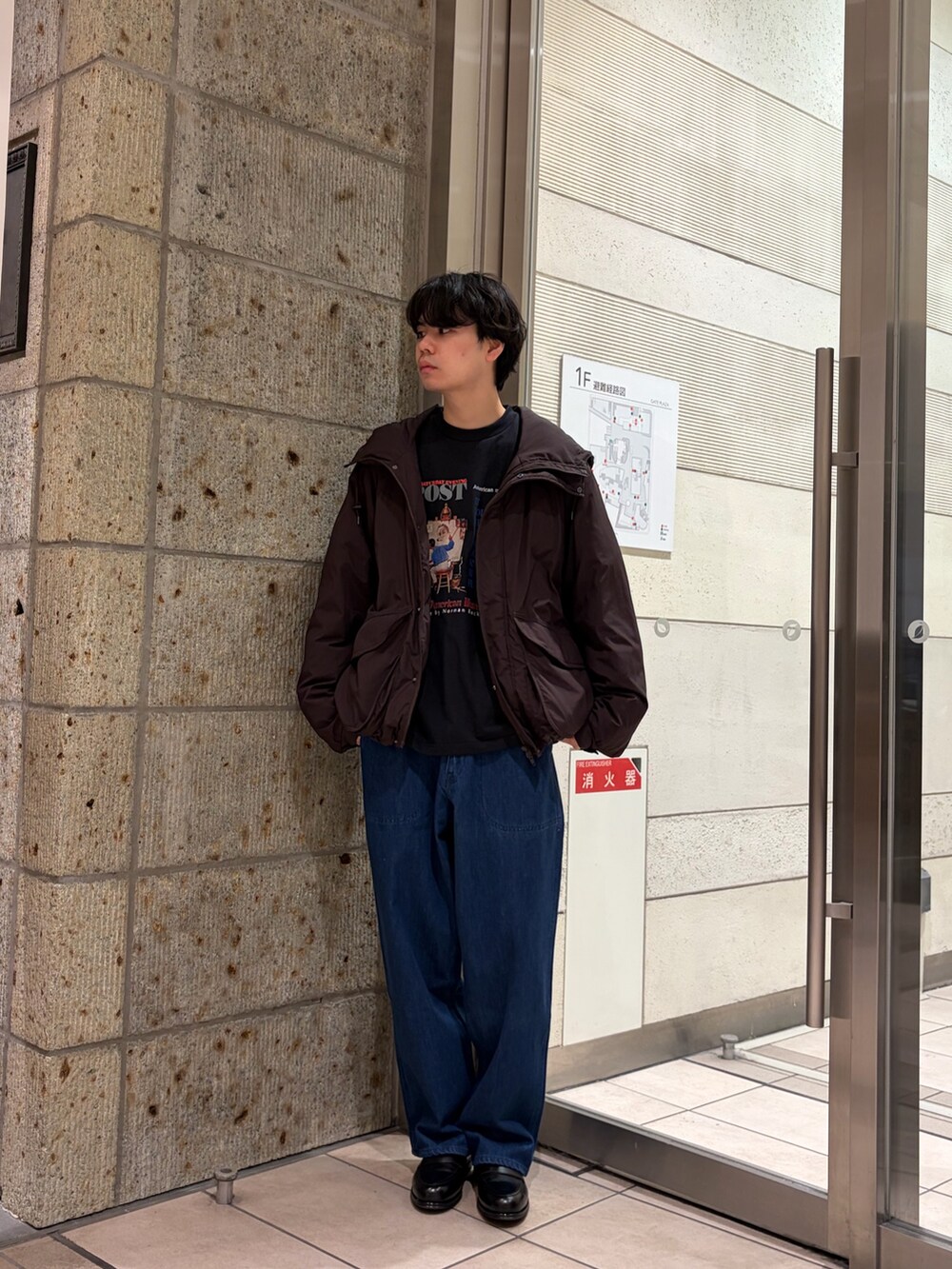 ブラック系のTシャツ/カットソー、ブラウン系のブルゾン、ブルー系のデニムパンツを着用したメンズの冬コーディネートの2枚目の写真