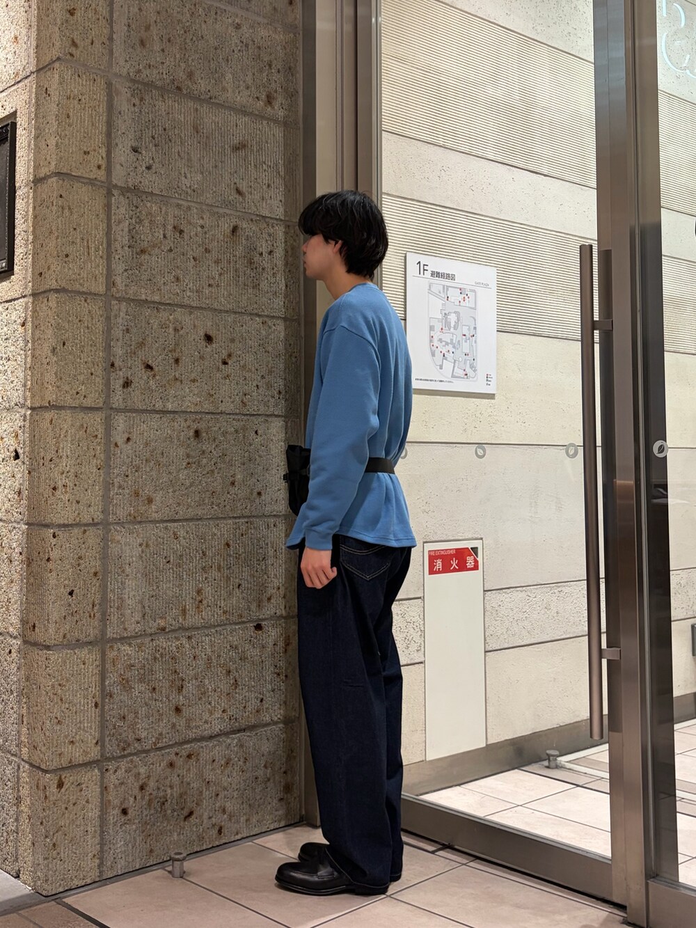 ブルー系のTシャツ/カットソー、ブルー系のデニムパンツ、ブラック系のドレスシューズを着用したメンズの春コーディネートの2枚目の写真