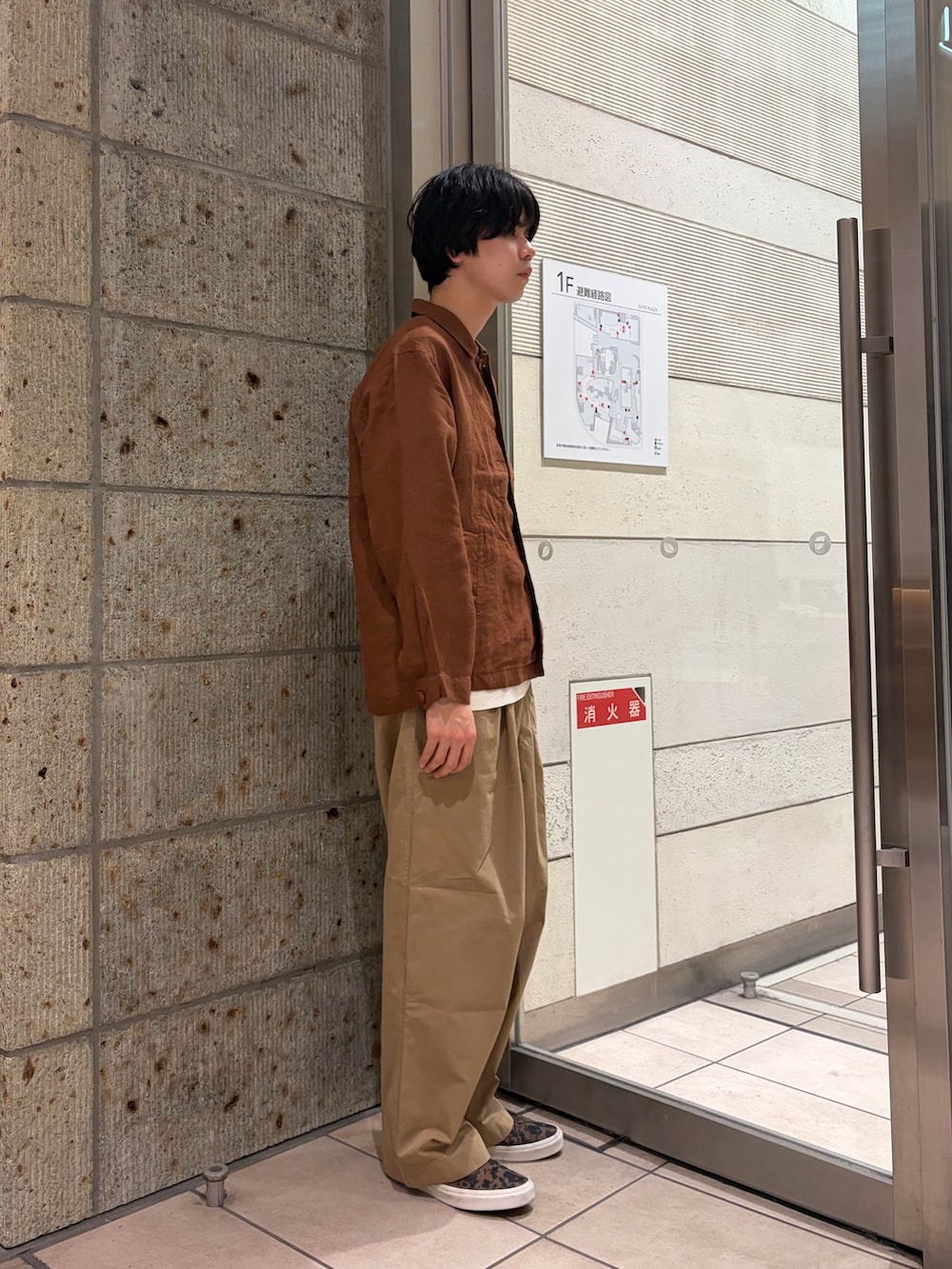 ブラウン系のその他アウター、ブラウン系のスニーカー、ベージュ系のTシャツ/カットソーを着用したメンズの春コーディネートの6枚目の写真