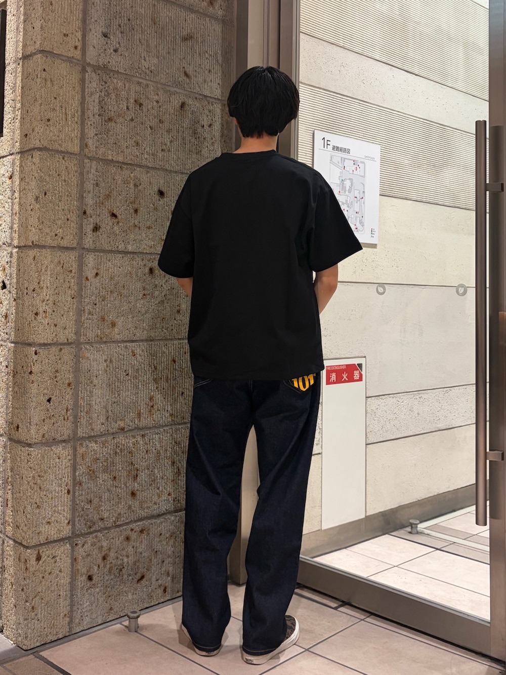 グリーン系のブルゾン、ブラック系のTシャツ/カットソー、ブルー系のデニムパンツを着用したメンズの春コーディネートの6枚目の写真