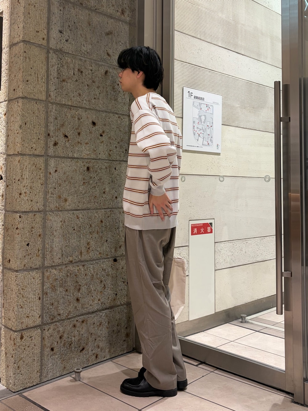 グレー系のニット/セーター、ベージュ系のその他パンツ、ベージュ系のショルダーバッグを着用したメンズの冬コーディネートの4枚目の写真