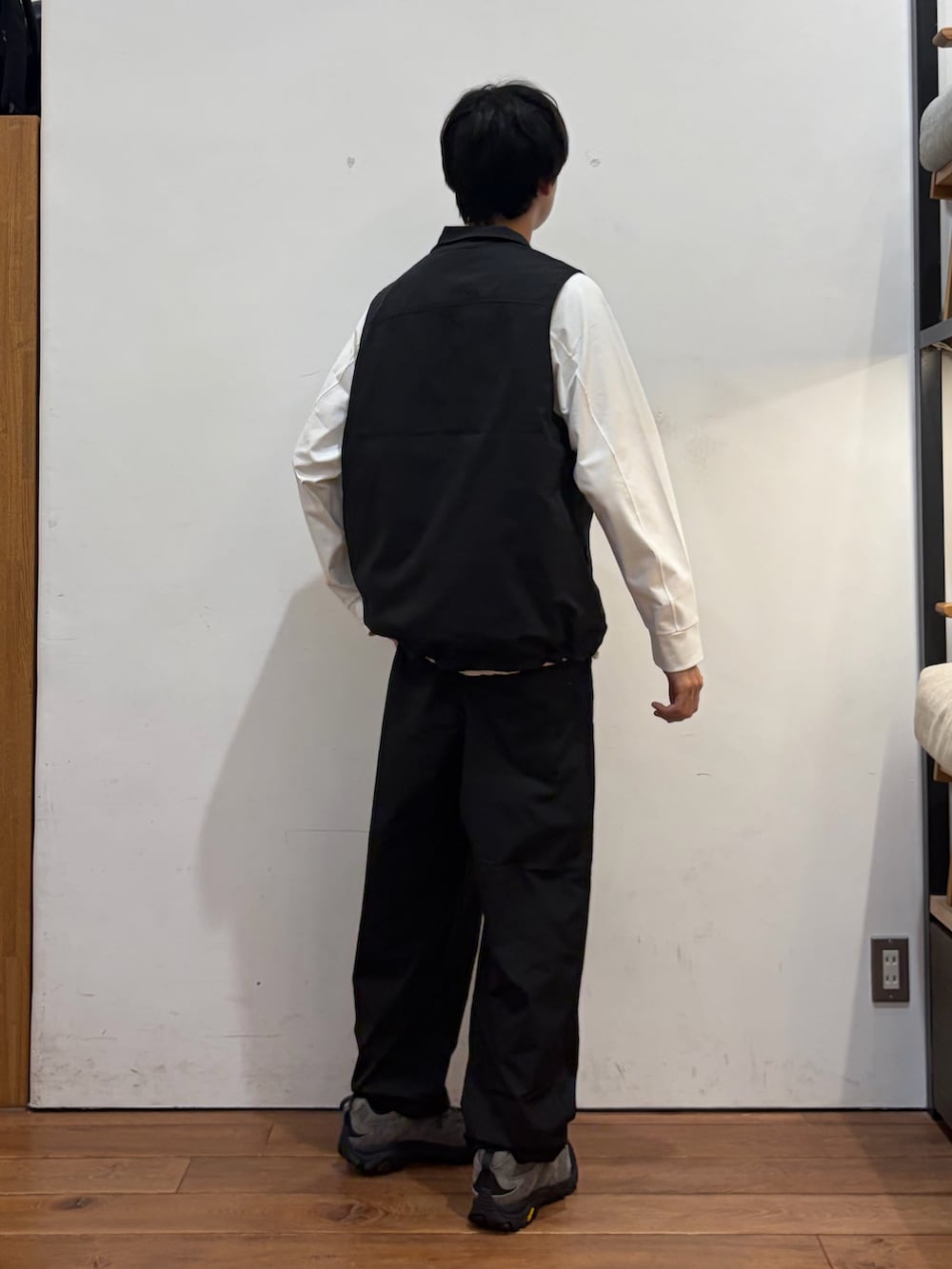 ブラック系のベスト、ホワイト系のTシャツ/カットソー、ブラック系のその他パンツを着用したメンズの秋コーディネートの3枚目の写真