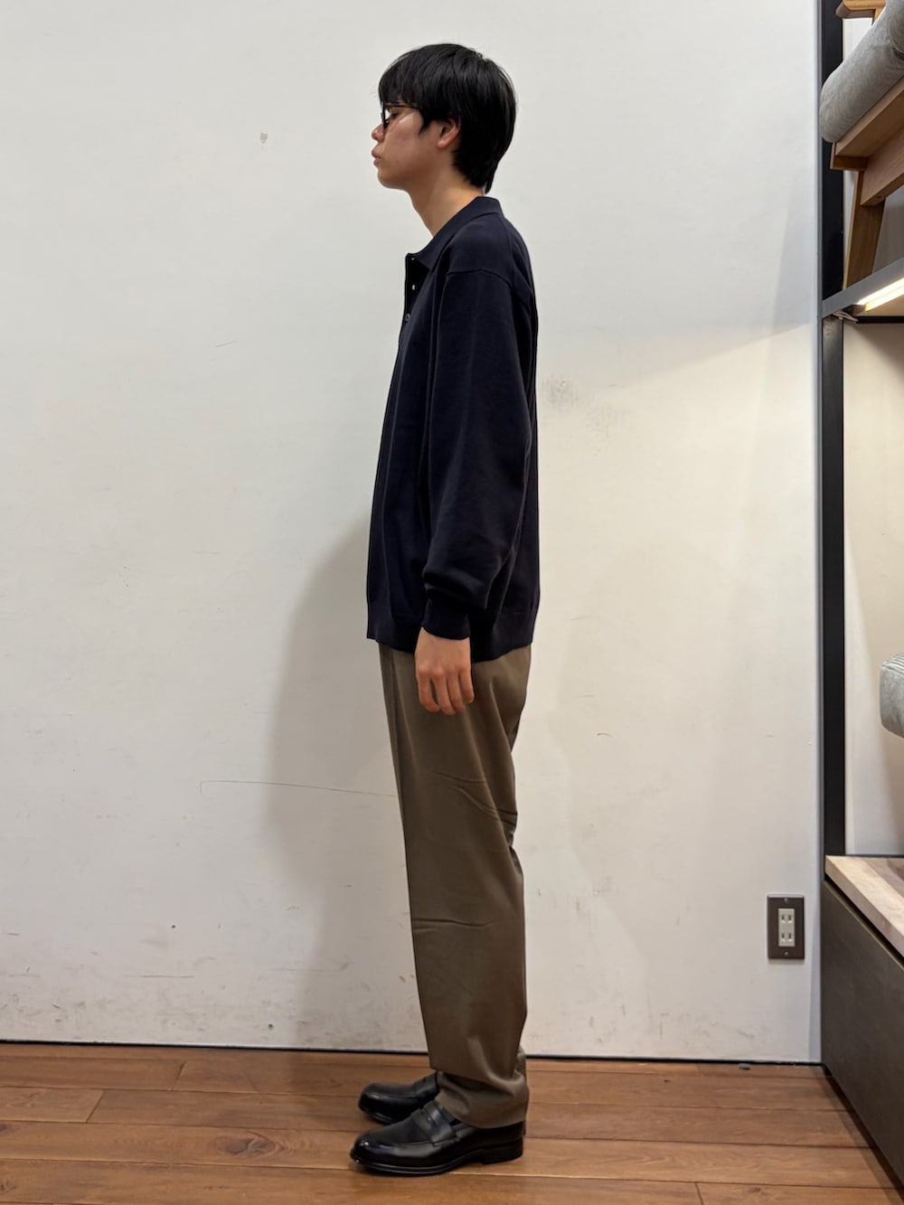 ブルー系のニット/セーター、グリーン系のその他パンツ、ブラック系のドレスシューズを着用したメンズの秋コーディネートの2枚目の写真