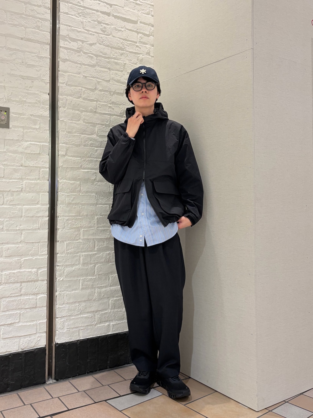 ブラック系のマウンテンパーカー、ブルー系のシャツ/ブラウス、ブルー系のその他パンツを着用したメンズの春コーディネートの2枚目の写真