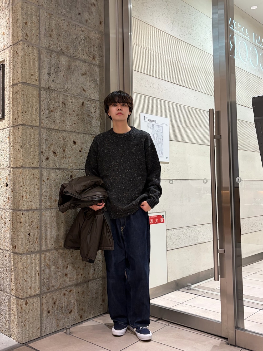 グレー系のニット/セーター、ブラウン系のブルゾン、ブルー系のデニムパンツを着用したメンズの冬コーディネートの3枚目の写真