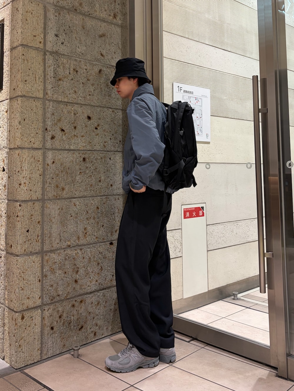 グレー系のブルゾン、ブルー系のその他パンツ、ブラック系のバックパック/リュックを着用したメンズの春コーディネートの3枚目の写真