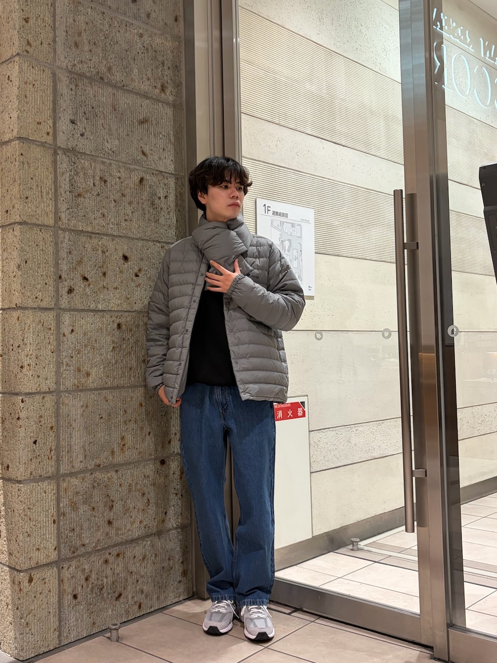 ブルー系のデニムパンツ、グレー系のスニーカー、グレー系のダウンジャケット/コートを着用したメンズの冬コーディネートの2枚目の写真
