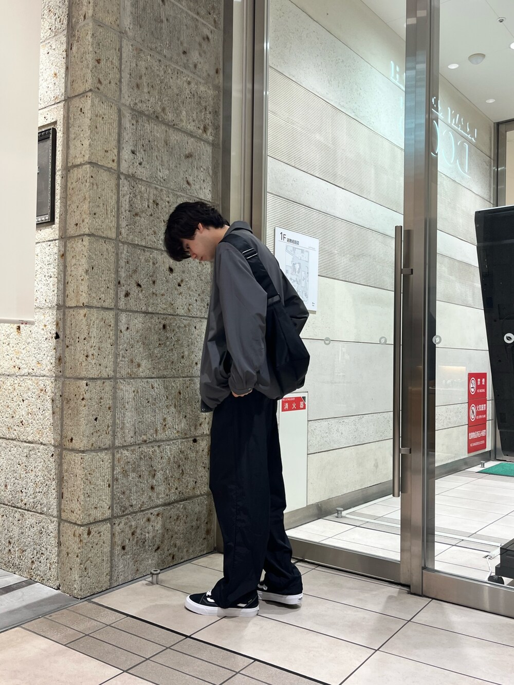 ブラック系のその他パンツ、ブラック系のスニーカー、ホワイト系のTシャツ/カットソーを着用したメンズの秋コーディネートの4枚目の写真