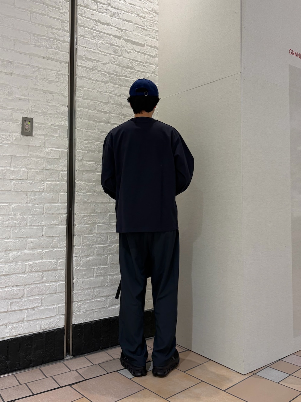 グレー系のTシャツ/カットソー、ブラック系のショルダーバッグ、ブラック系のスニーカーを着用したメンズの春コーディネートの4枚目の写真