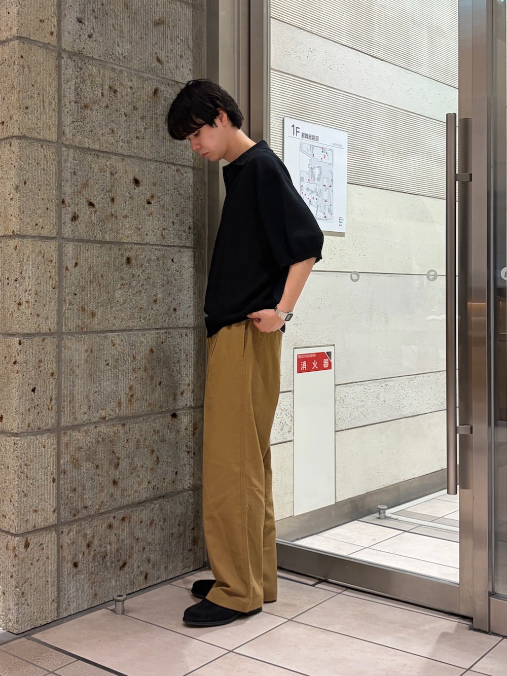 ブラック系のニット/セーター、ベージュ系のその他パンツ、ブラック系のドレスシューズを着用したメンズの夏コーディネートの3枚目の写真