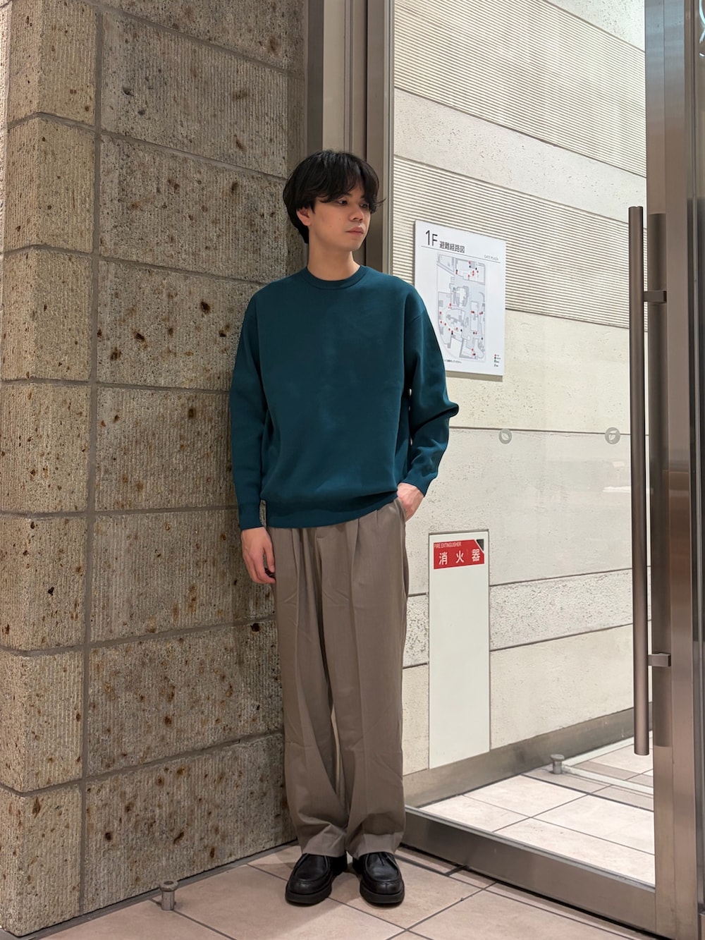 グリーン系のニット/セーター、ベージュ系のその他パンツ、ブラック系のドレスシューズを着用したメンズの冬コーディネートの4枚目の写真