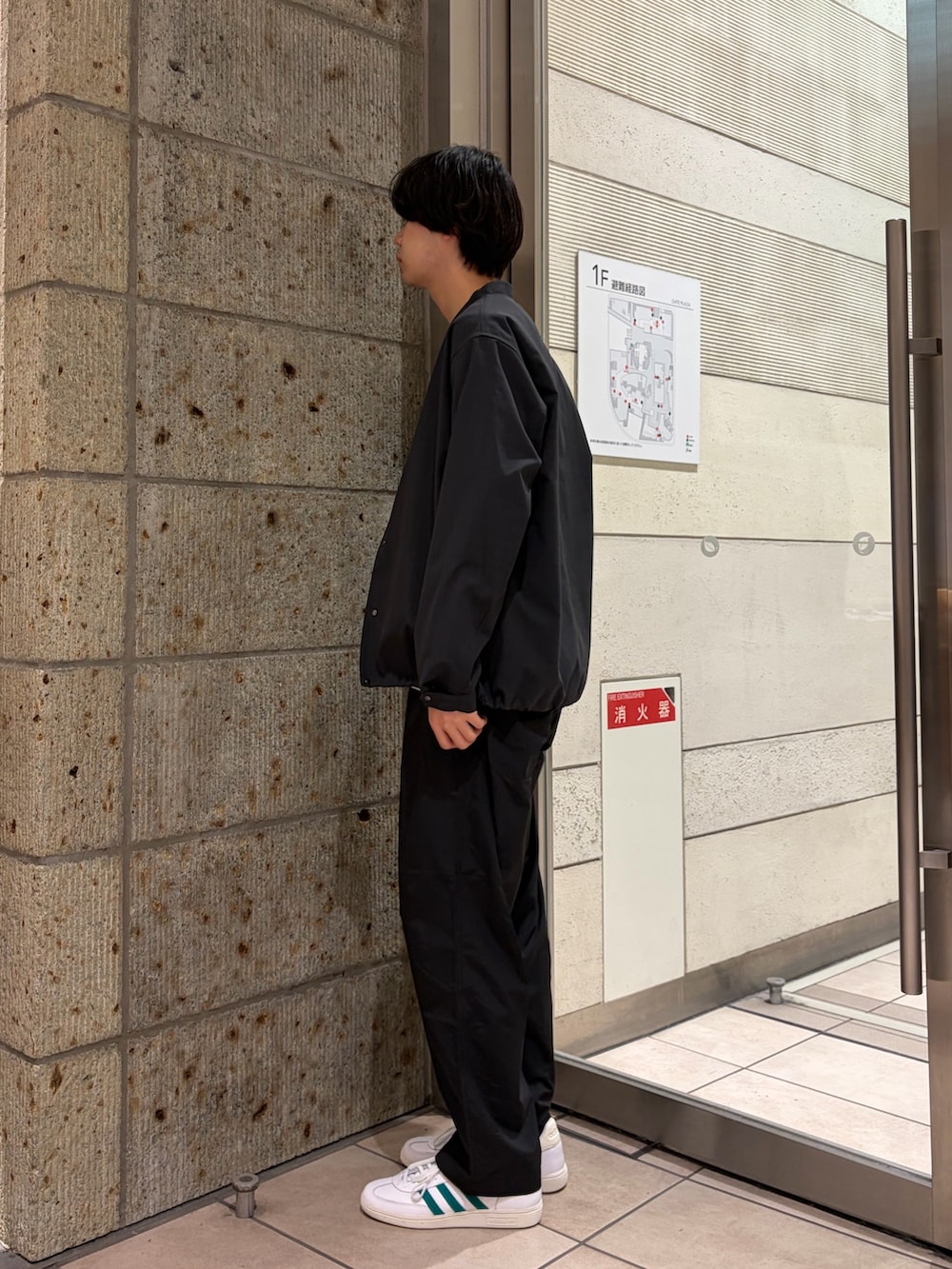 グレー系のブルゾン、ホワイト系のTシャツ/カットソー、ブラック系のその他パンツを着用したメンズの春コーディネートの2枚目の写真