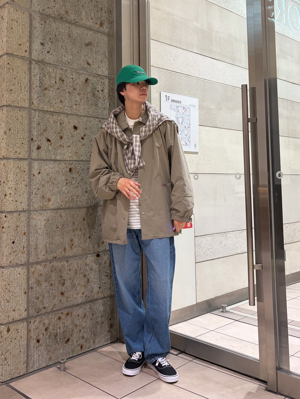 ベージュ系のその他アウター、グリーン系のブルゾン、ホワイト系のTシャツ/カットソーを着用したメンズの春コーディネートの2枚目の写真