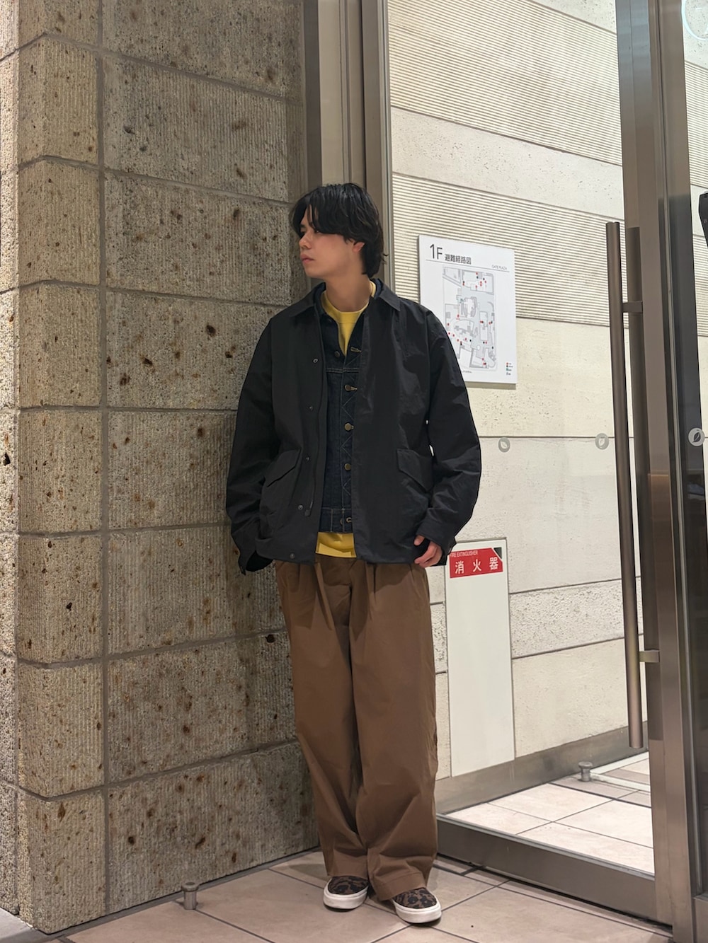 ブラック系のナイロンジャケット、ブルー系のデニムジャケット、イエロー系のTシャツ/カットソーを着用したメンズの春コーディネートの3枚目の写真