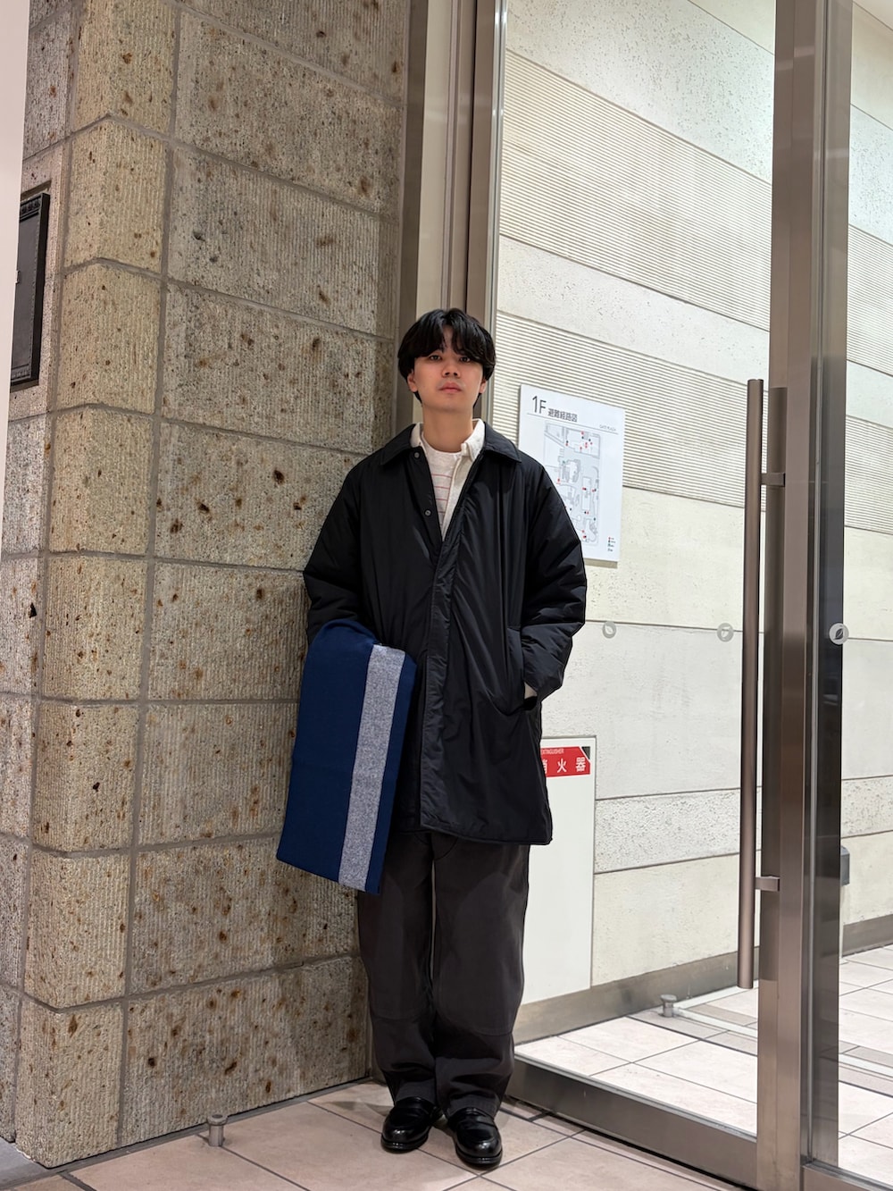 ブラック系のその他アウター、グレー系のその他パンツ、ブラック系のドレスシューズを着用したメンズの冬コーディネートの5枚目の写真