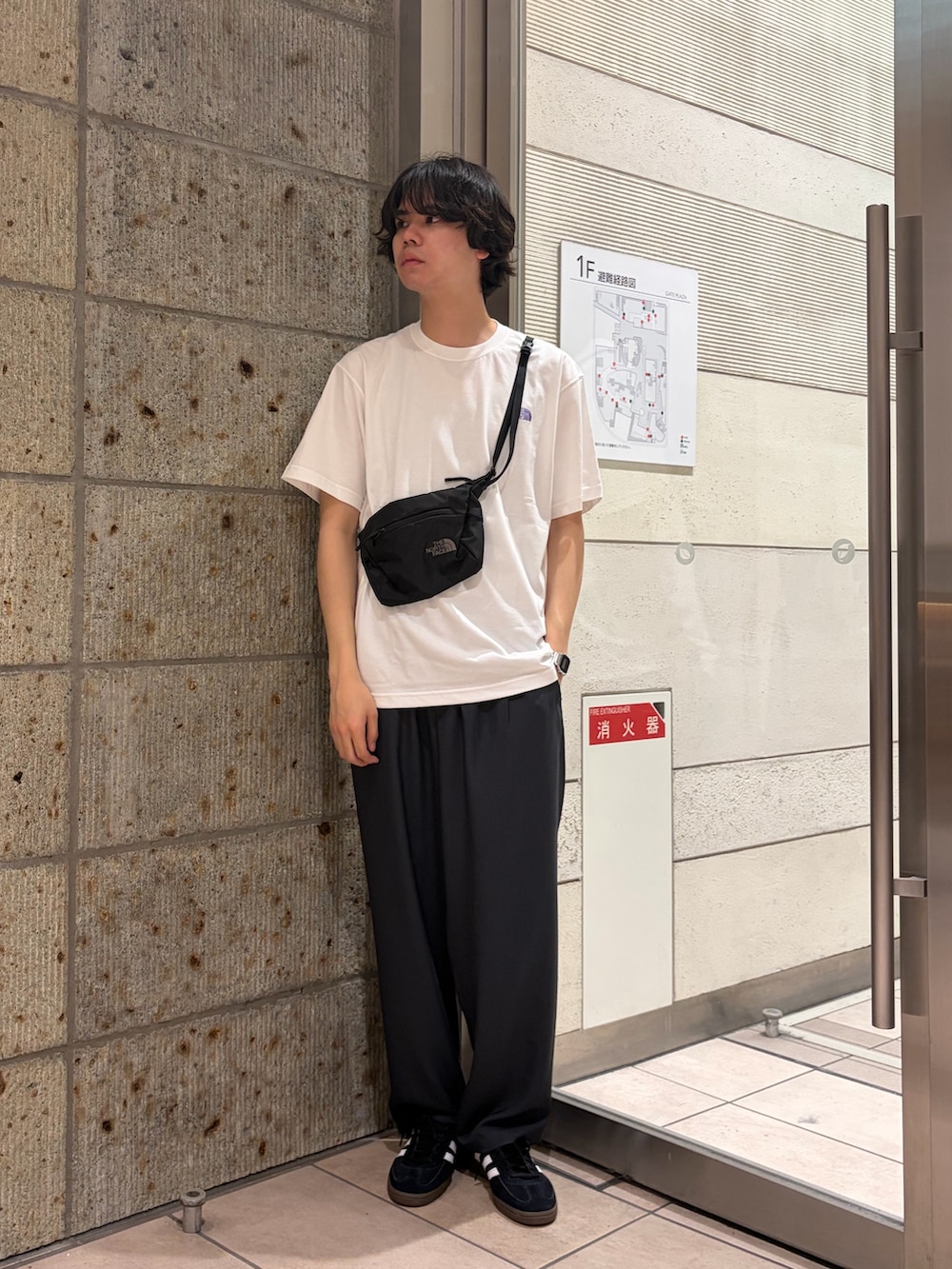 ホワイト系のTシャツ/カットソー、ブラック系のショルダーバッグ、グレー系のその他パンツを着用したメンズの春コーディネートの2枚目の写真