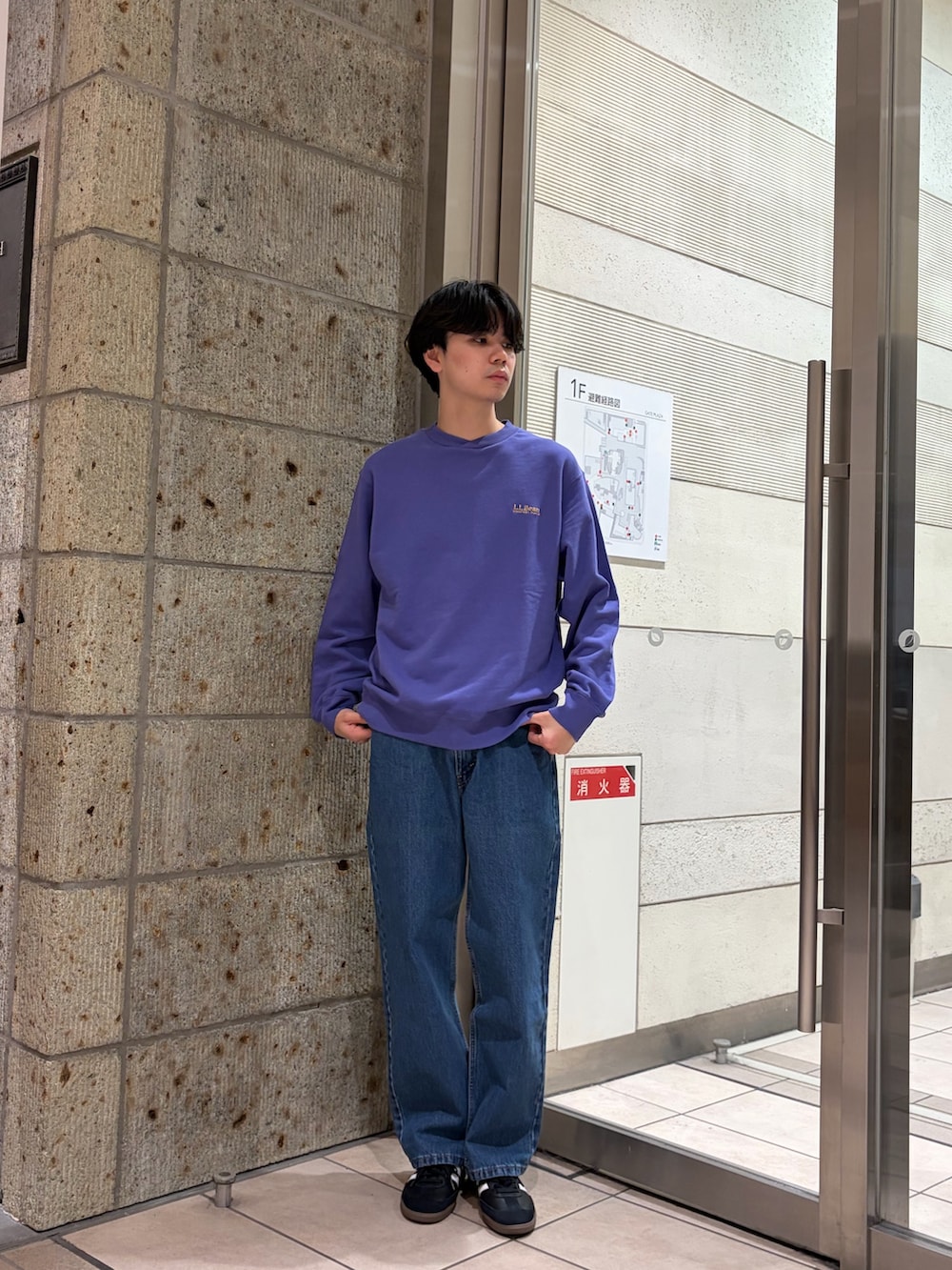 ブルー系のスウェット、ブラック系のスニーカー、ブルー系のデニムパンツを着用したメンズの冬コーディネートの2枚目の写真