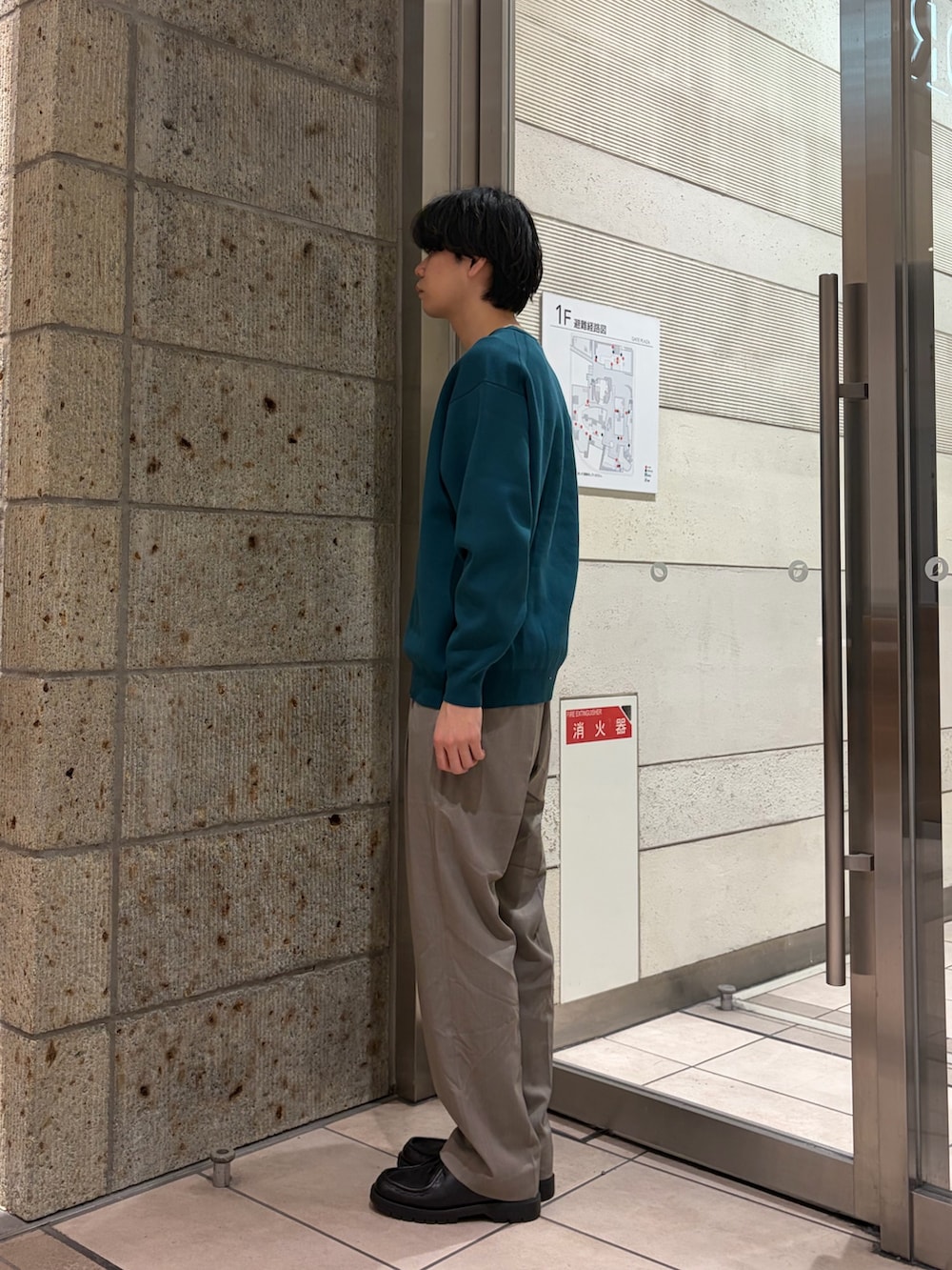 グリーン系のニット/セーター、ベージュ系のその他パンツ、ブラック系のドレスシューズを着用したメンズの冬コーディネートの3枚目の写真