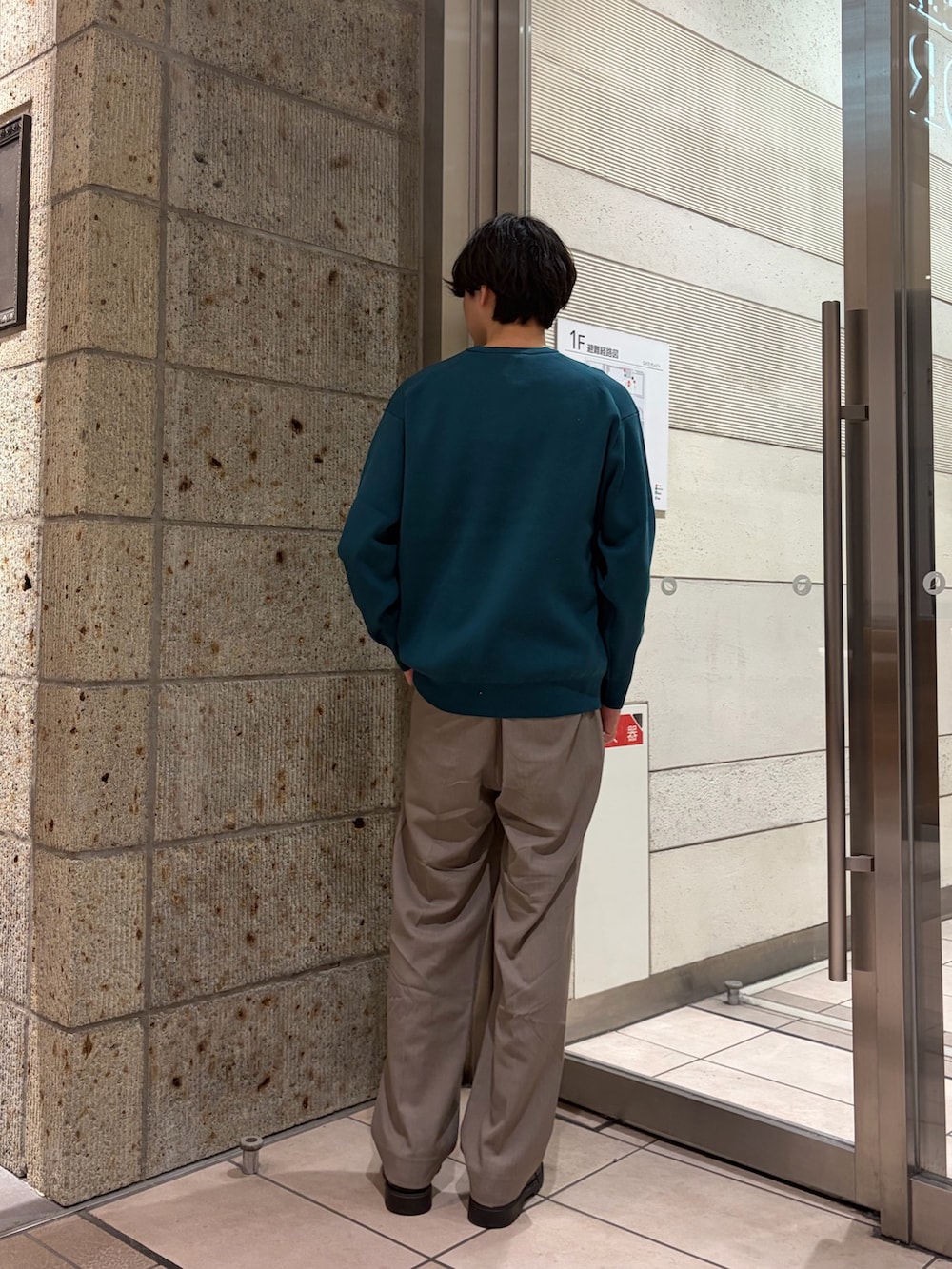 グリーン系のニット/セーター、ベージュ系のその他パンツ、ブラック系のドレスシューズを着用したメンズの冬コーディネートの2枚目の写真