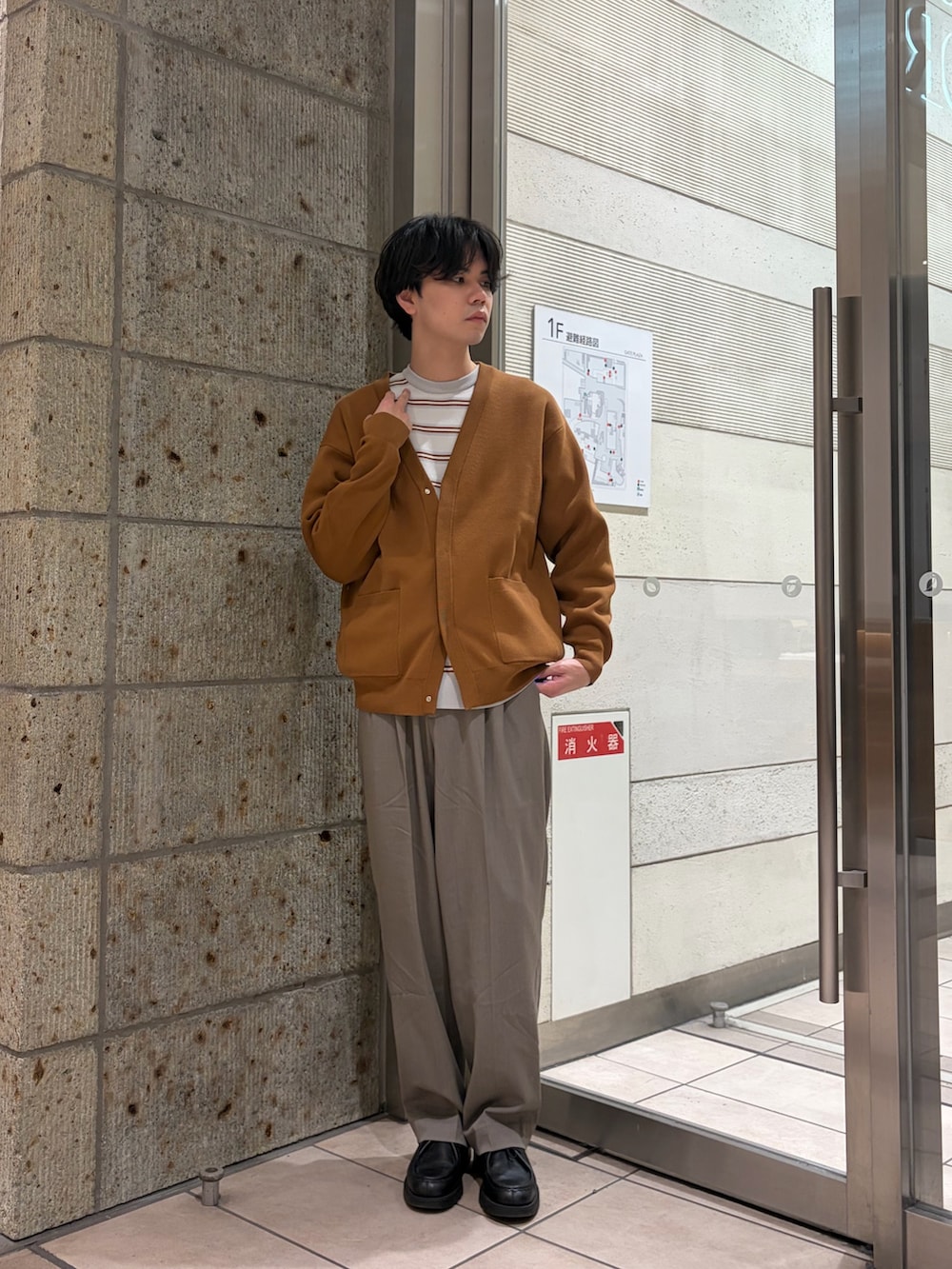 ブラウン系のカーディガン/ボレロ、グレー系のニット/セーター、ベージュ系のその他パンツを着用したメンズの冬コーディネートの2枚目の写真