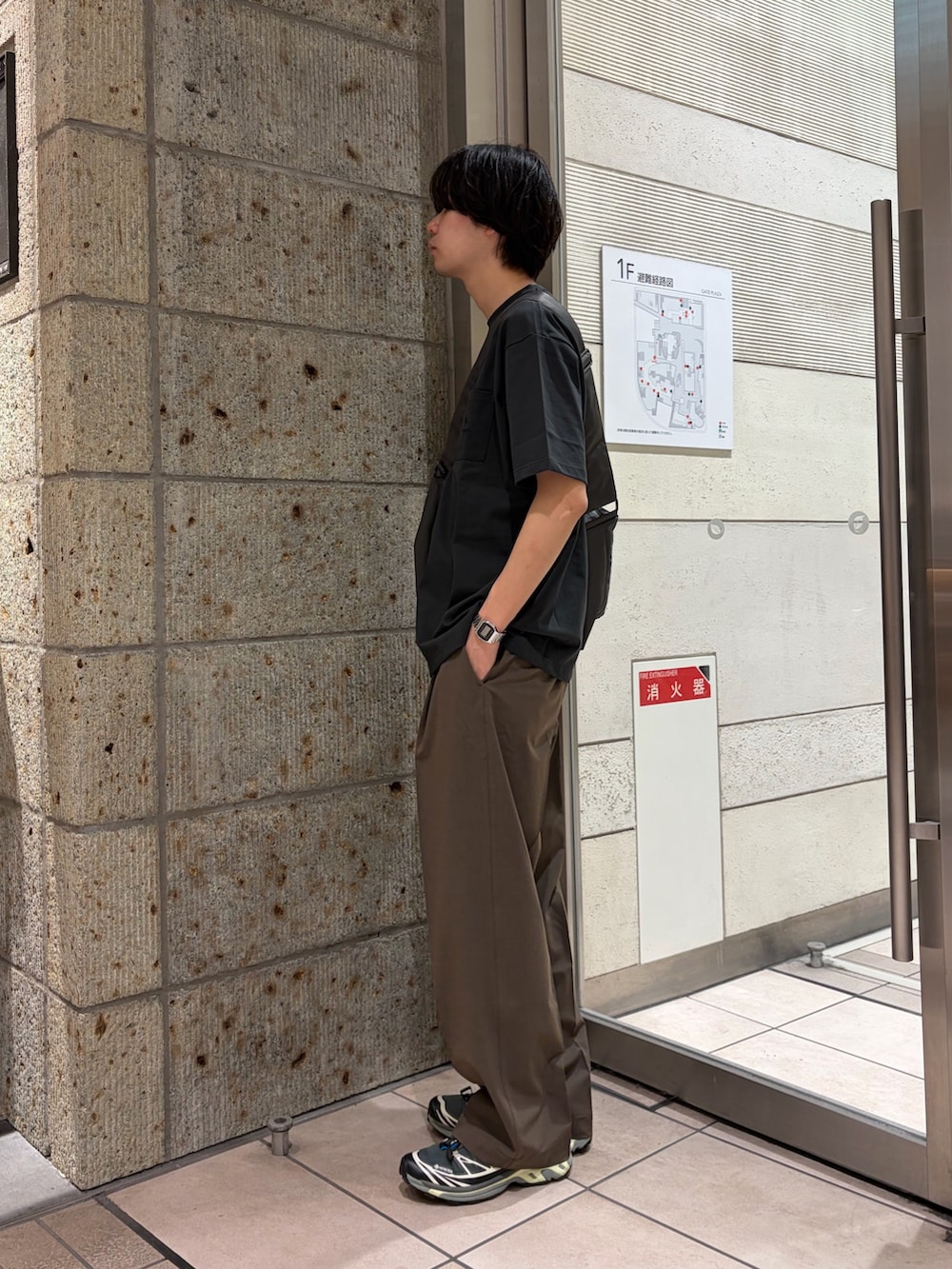 グレー系のTシャツ/カットソー、グレー系のショルダーバッグ、ブラック系のスニーカーを着用したメンズの春コーディネートの4枚目の写真