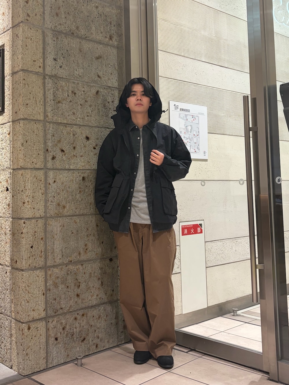 ブラック系のマウンテンパーカー、ブラック系のシャツ/ブラウス、グレー系のTシャツ/カットソーを着用したメンズの冬コーディネートの2枚目の写真