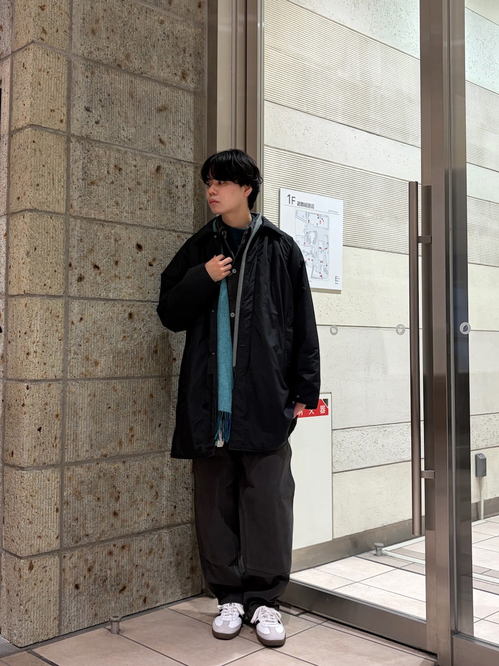 ブラック系のその他アウター、グレー系のカバーオール、グリーン系のニット/セーターを着用したメンズの冬コーディネートの2枚目の写真