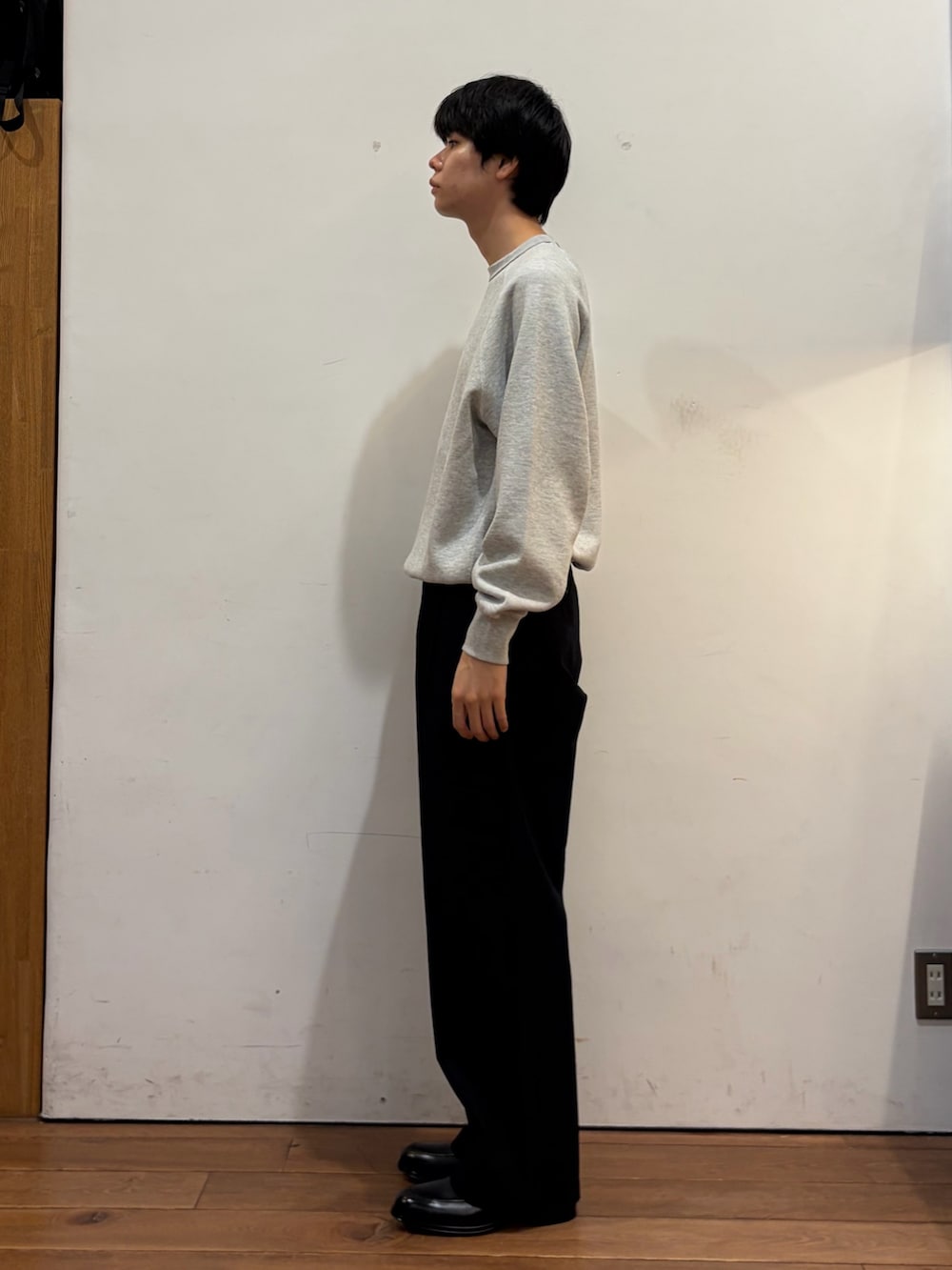 グレー系のスウェット、ブルー系のその他パンツ、ブラック系のドレスシューズを着用したメンズの秋コーディネートの4枚目の写真