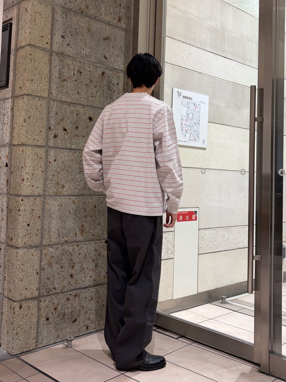 レッド系のTシャツ/カットソー、ブラック系のドレスシューズ、グレー系のその他パンツを着用したメンズの冬コーディネートの4枚目の写真