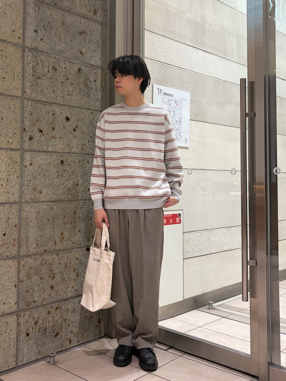 グレー系のニット/セーター、ベージュ系のその他パンツ、ベージュ系のショルダーバッグを着用したメンズの冬コーディネートの2枚目の写真