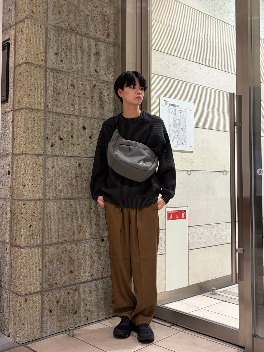 グレー系のニット/セーター、ベージュ系のその他パンツ、グレー系のショルダーバッグを着用したメンズの冬コーディネートの2枚目の写真