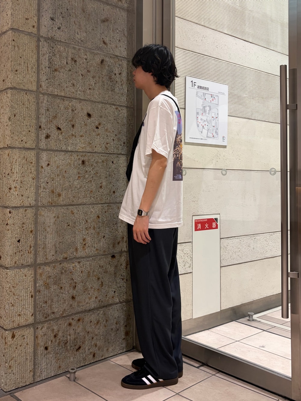 ホワイト系のTシャツ/カットソー、ブラック系のショルダーバッグ、グレー系のその他パンツを着用したメンズの春コーディネートの3枚目の写真