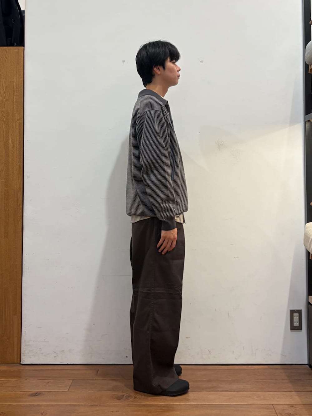 グレー系のニット/セーター、ホワイト系のシャツ/ブラウス、ブラウン系のその他パンツを着用したメンズの秋コーディネートの5枚目の写真