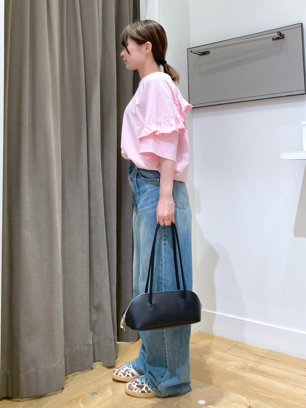 ピンク系のTシャツ/カットソー、ブルー系のデニムパンツ、ブラック系のボストンバッグを着用したレディースの夏コーディネートの2枚目の写真
