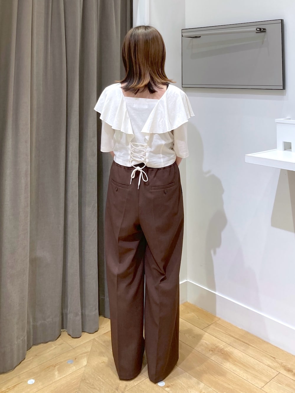 ホワイト系のTシャツ/カットソー、ブラウン系のスラックスを着用したレディースの夏コーディネートの3枚目の写真