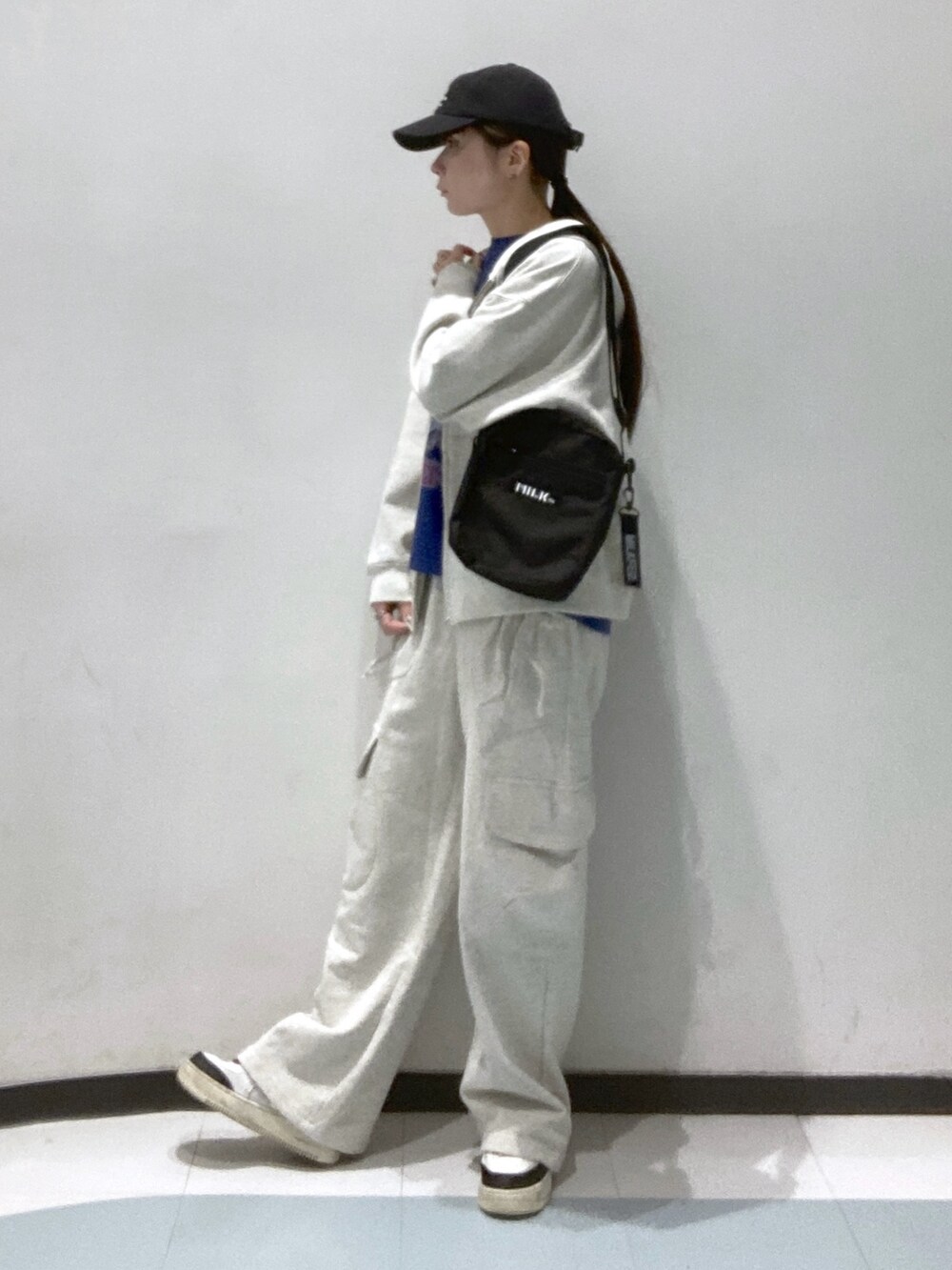 ベージュ系のスウェットパンツ、ブラック系のショルダーバッグ、ベージュ系のパーカーを着用したレディースの冬コーディネートの2枚目の写真