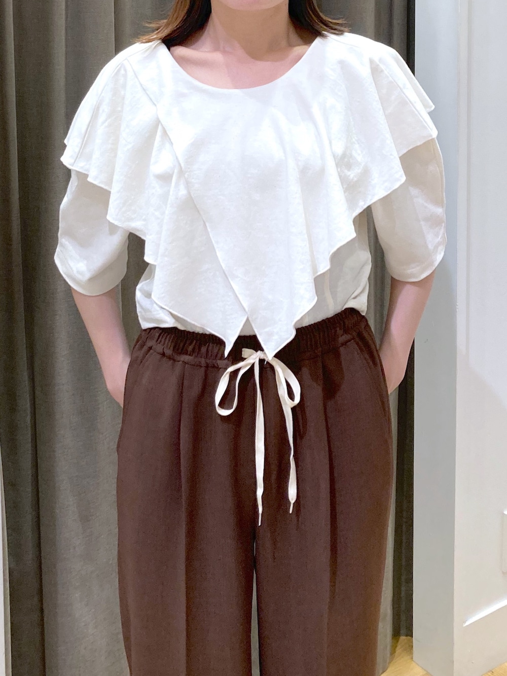 ホワイト系のTシャツ/カットソー、ブラウン系のスラックスを着用したレディースの夏コーディネートの4枚目の写真