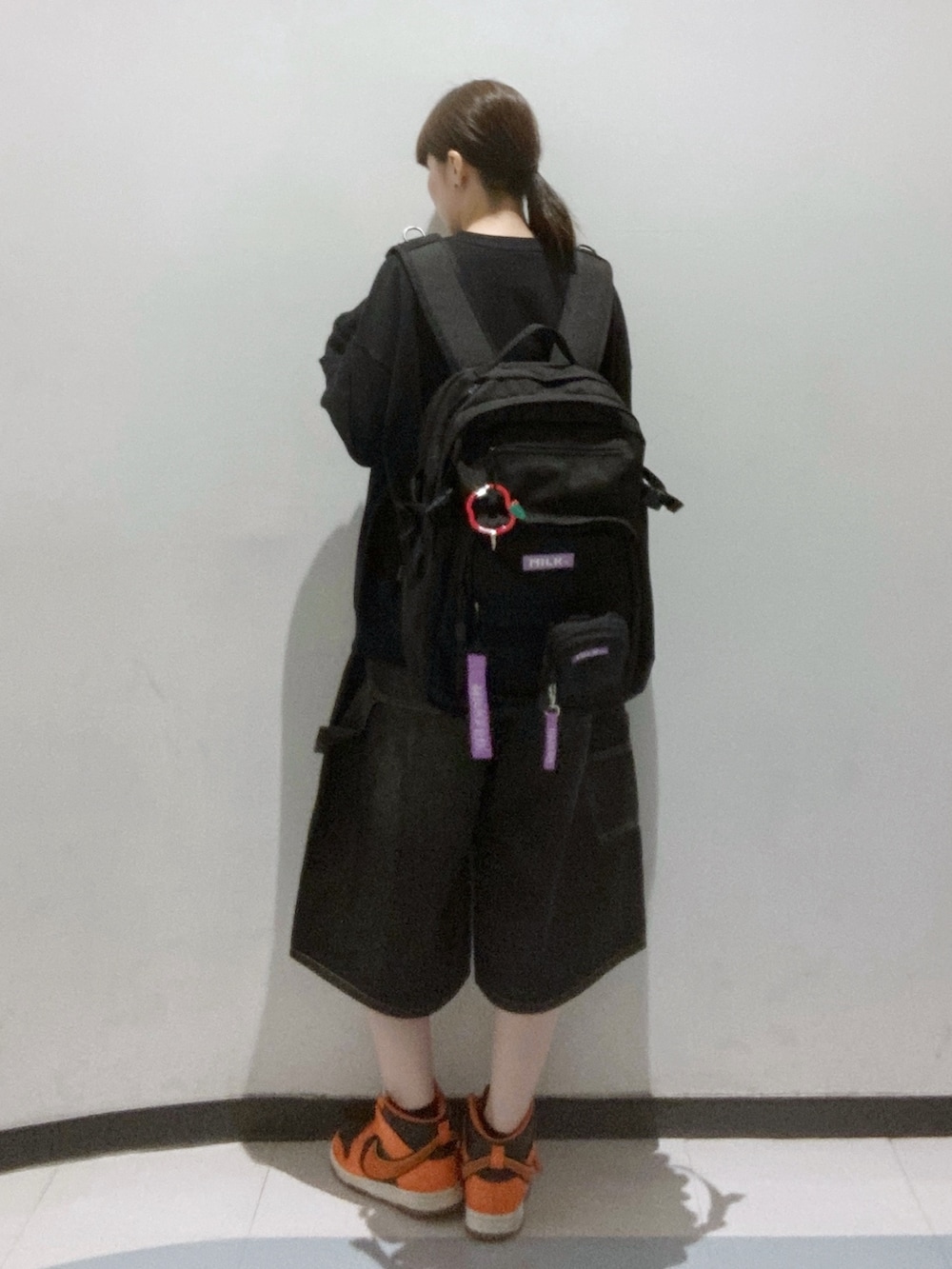 ブラック系のスウェット、パープル系のショルダーバッグ、パープル系のバックパック/リュックを着用したレディースの秋コーディネートの2枚目の写真