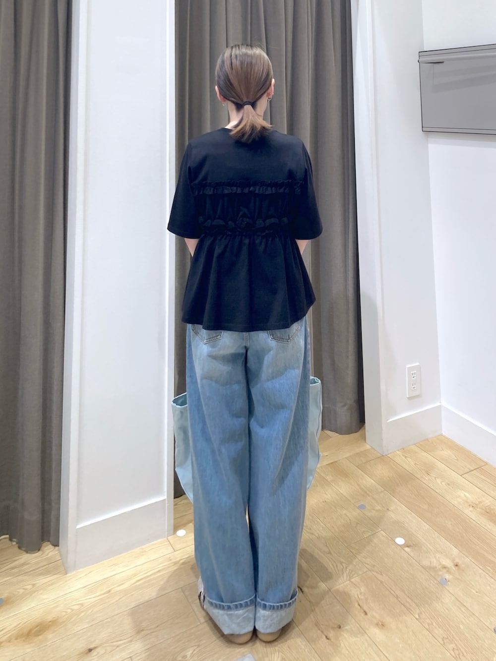 ブラック系のTシャツ/カットソー、ブルー系のデニムパンツ、ブルー系のトートバッグを着用したレディースの夏コーディネートの3枚目の写真