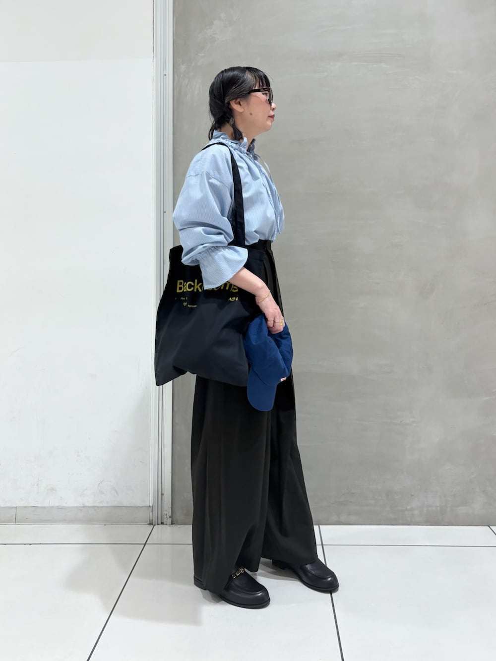 ブルー系のシャツ/ブラウス、ブラウン系のその他パンツ、ブラック系のローファーを着用したレディースの秋コーディネートの2枚目の写真