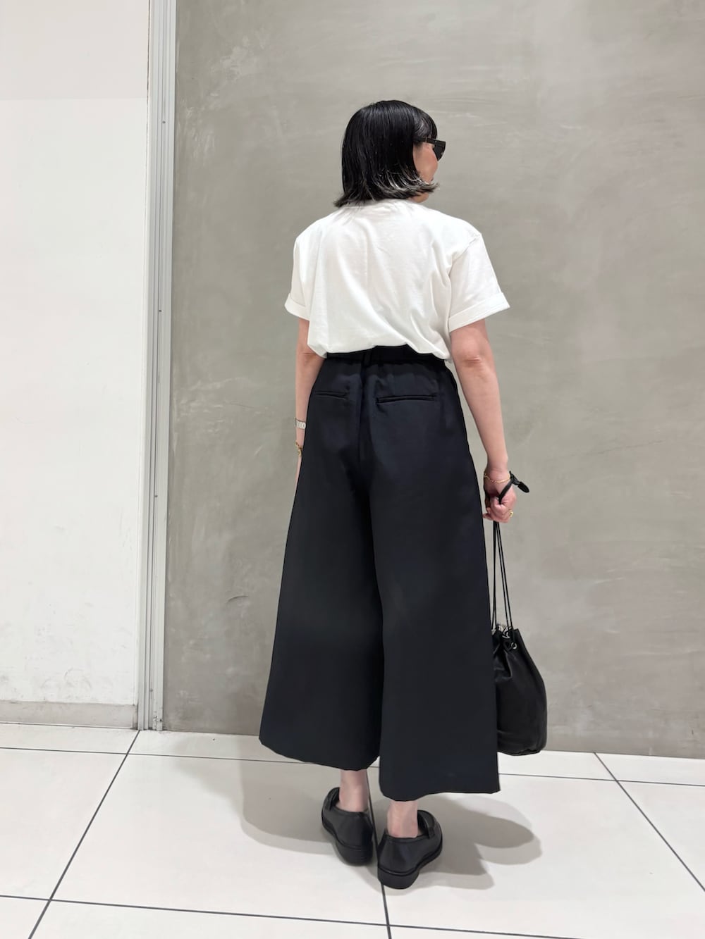 ホワイト系のTシャツ/カットソー、ブラック系のその他パンツ、ブラック系のローファーを着用したレディースの夏コーディネートの2枚目の写真